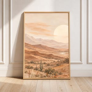 Pode incluir: Uma impressão de arte vertical emoldurada retratando uma paisagem desértica em tons de bege, castanho e terracota. A cena apresenta colinas onduladas, um grande sol no céu, vegetação desértica esparsa e um cacto saguaro em primeiro plano.