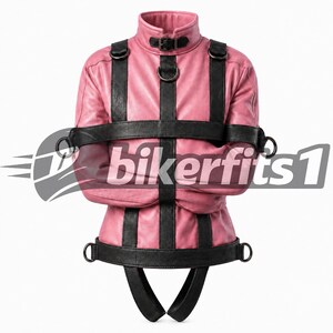 May include: A pink leather jacket featuring black leather straps, metal D-rings, and a high collar with a buckle closure. The garment includes vertical and horizontal straps across the chest and waist, with two downward-extending straps at the base.