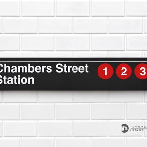 May include: Black and white sign with white text that reads "Chambers Street Station" and red circles with the numbers "1", "2", and "3" on a white tiled wall.