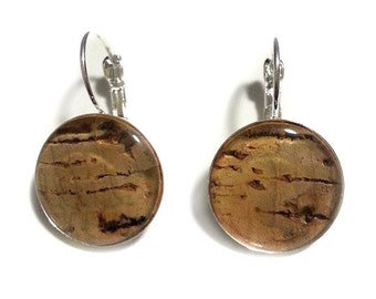 May include: A pair of round earrings with a silver-colored lever back. The earrings feature a brown and tan marbled design, encased in a clear, glossy resin. The earrings are set against a white background.