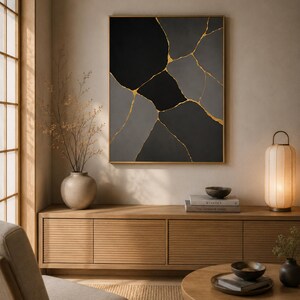 Può includere: Un'opera d'arte murale rettangolare caratterizzata da una composizione astratta di forme geometriche nere e grigie separate da sottili linee dorate irregolari. L'opera è incorniciata da un sottile bordo dorato ed è appesa a una parete.
