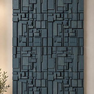 Puede incluir: Una gran pieza de arte mural rectangular compuesta por numerosos bloques de madera de color azul oscuro de diversos tamaños y profundidades, dispuestos en un patrón de cuadrícula para crear una textura geométrica tridimensional.