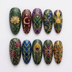 May include: A set of ten oval-shaped press-on nails featuring intricate raised designs. Patterns include a gold lotus, a crescent moon, a purple lattice, blue berries, a sunburst, red roses, blue scales, a peacock feather, a floral mandala, and autumn leaves.