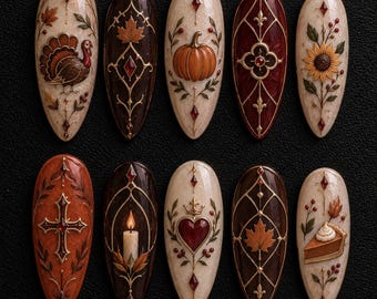 May include: Ten almond-shaped press-on nails featuring intricate autumn-themed designs. Motifs include a turkey, pumpkin, sunflower, cross, lit candle, heart with a crown, maple leaves, and a slice of pumpkin pie, accented with gold filigree.