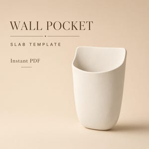 Puede incluir: Un documento digital titulado WALL POCKET SLAB TEMPLATE Instant PDF que muestra un bolsillo de pared de cerámica en forma de U, de color blanco roto, con una parte superior abierta y una base redondeada sobre un fondo beige claro.