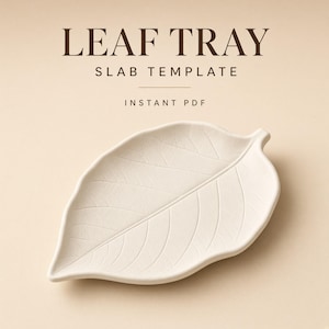 Puede incluir: Una bandeja en forma de hoja de color crema con detalles de venas en relieve. El texto LEAF TRAY SLAB TEMPLATE INSTANT PDF está impreso en marrón oscuro sobre la bandeja. La bandeja tiene un acabado mate liso y una punta afilada.