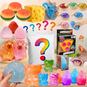 Op de afbeelding: Een verzameling diverse squishy speeltjes waaronder hamburger-, kaas-, aardbei- en beervormige figuren, samen met een mysteriezakje gemarkeerd met een vraagteken, een Squeezza pizzadoos en diverse kleurrijke, doorschijnende en glinsterende slijmachtige items.