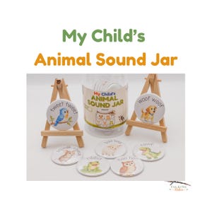 May include: A clear plastic jar labeled My Child's Animal Sound Jar, accompanied by seven circular buttons featuring illustrations of animals and their sounds, including a bird, dog, mouse, frog, sheep, owl, and dinosaur, displayed on two wooden easels.