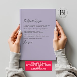 May include: A light purple hardcover book featuring black printed text that reads: The Adventure Begins. It feels like yesterday we were holding your hand—and now you hold the whole world in yours. We are so proud of the person you've become.