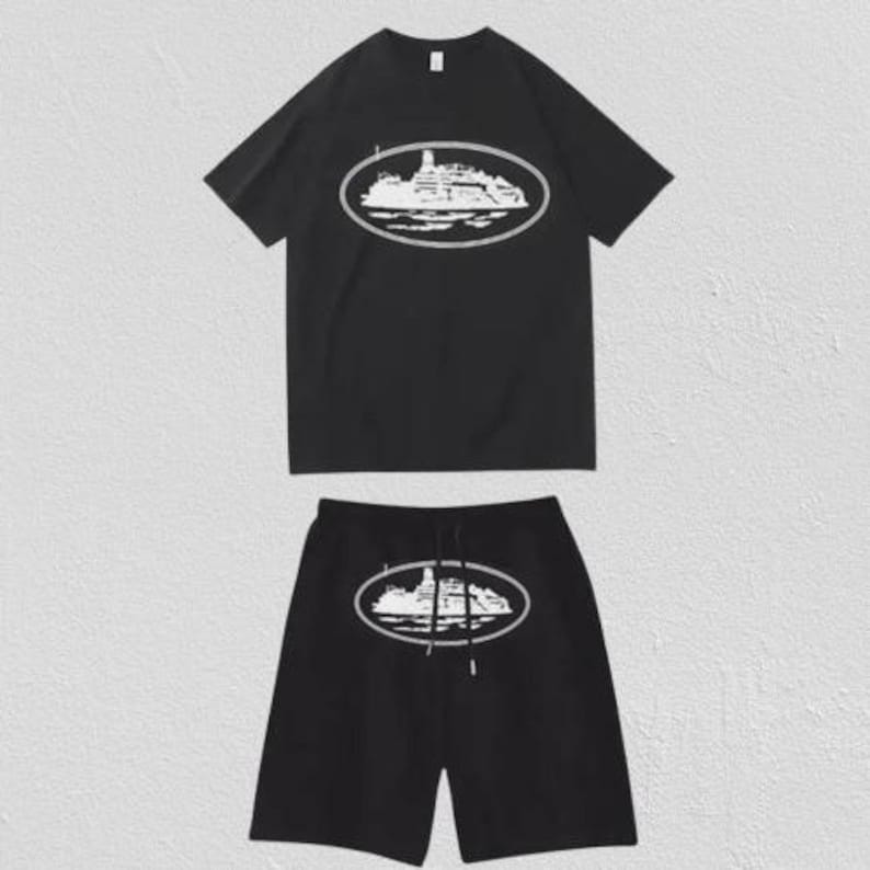 Puede incluir: Un conjunto de camiseta de manga corta y pantal&oacute;n corto en color negro. Ambas prendas presentan un estampado gr&aacute;fico blanco de un barco dentro de un marco ovalado, centrado en el pecho y en el muslo. El pantal&oacute;n corto incluye un cord&oacute;n negro.
