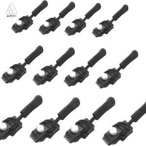 May include: A set of twelve black zipper pull replacements featuring a textured grip, a black cord loop, and a silver-colored metal screw mechanism. Each unit is identical, designed for attachment to zipper sliders, and includes the logo ARHI.