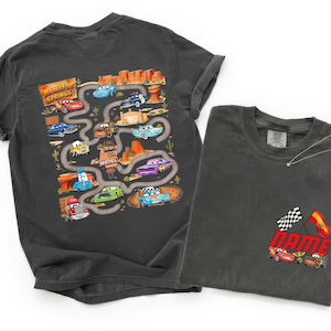 May include: A charcoal gray t-shirt featuring a back graphic of a winding road through Radiator Springs with various cartoon cars and a front chest graphic showing the word NAME with two racing flags and two cartoon cars at the bottom.