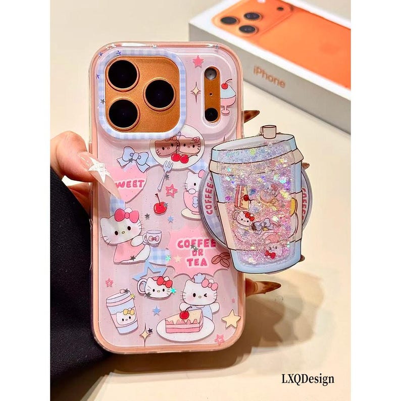 May include: A clear phone case featuring Hello Kitty graphics, pink hearts, stars, and the text Coffee or Tea. The case includes a circular, glitter-filled pop-out grip shaped like a beverage cup with small character icons inside the liquid.