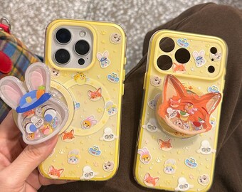 Capa MagSafe para iPhone Zootopia Judy Nick, com estampa de coelho e raposa amarelos e PopSocket com função de agitação. Capa de TPU resistente a impactos para iPhone 17/16/15/14/13 Pro Max.
