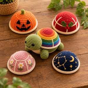 Peut inclure: Une tortue crochetée avec une carapace aux couleurs de l'arc-en-ciel entourée de quatre housses interchangeables en forme de dôme : une citrouille orange, une housse rouge sur le thème de Noël avec du houx, une housse rose à fleurs et une bleue.