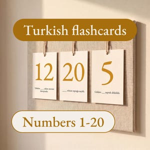 May include: Three rectangular off-white flashcards hanging from a textured board by twine. The cards display the gold numbers 12, 20, and 5, each accompanied by a Turkish sentence with a blank space. Text overlays read Turkish flashcards and Numbers 1-20.