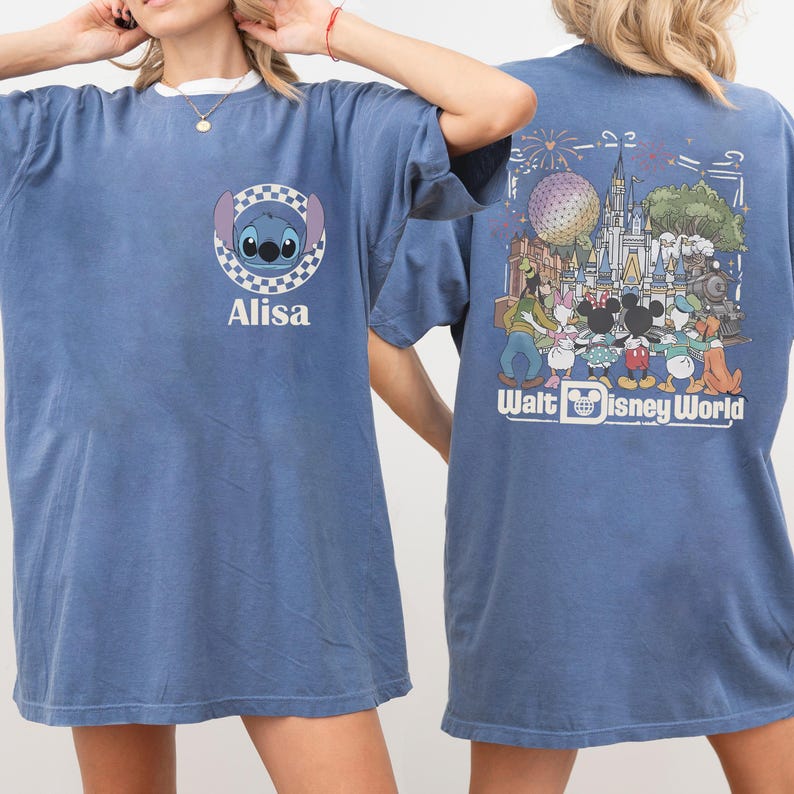 Puede incluir: Una camiseta azul con un gr&aacute;fico frontal de Stitch dentro de un c&iacute;rculo a cuadros con el nombre Alisa debajo. El gr&aacute;fico trasero muestra una escena colorida de personajes de Disney en Walt Disney World con un castillo, fuegos artificiales y el texto Walt Disney World.