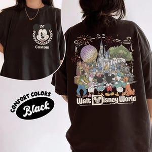 Puede incluir: Una camiseta negra con un peque&ntilde;o gr&aacute;fico frontal de una cabeza de Mickey Mouse gui&ntilde;ando un ojo dentro de un c&iacute;rculo a cuadros con la palabra Custom debajo. La parte posterior muestra una gran ilustraci&oacute;n colorida de personajes Disney.
