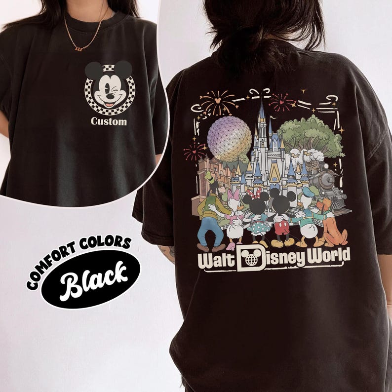 Puede incluir: Una camiseta negra con un peque&ntilde;o gr&aacute;fico frontal de una cabeza de Mickey Mouse gui&ntilde;ando un ojo dentro de un c&iacute;rculo a cuadros con la palabra Custom debajo. La parte posterior muestra una gran ilustraci&oacute;n colorida de personajes Disney.