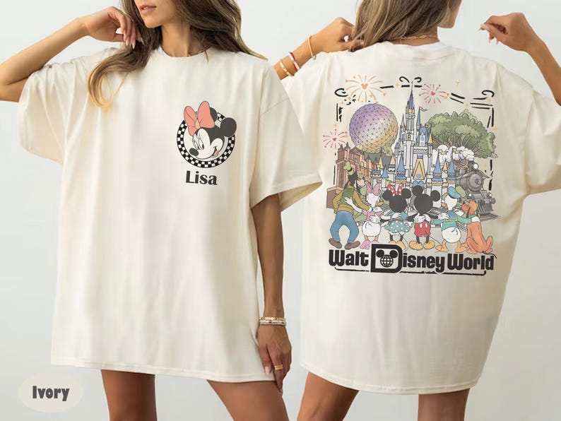 Puede incluir: Una camiseta color marfil con un peque&ntilde;o gr&aacute;fico de Minnie Mouse y el nombre Lisa en el pecho izquierdo. La parte posterior muestra una gran ilustraci&oacute;n colorida del castillo de Walt Disney World, fuegos artificiales y personajes.