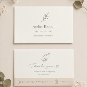May include: Two rectangular white business cards with dark gray text and line art. The top card displays Atelier Bloom, handmade accessories, and a leaf icon. The bottom card features a thank you message, a tag icon, and contact information.