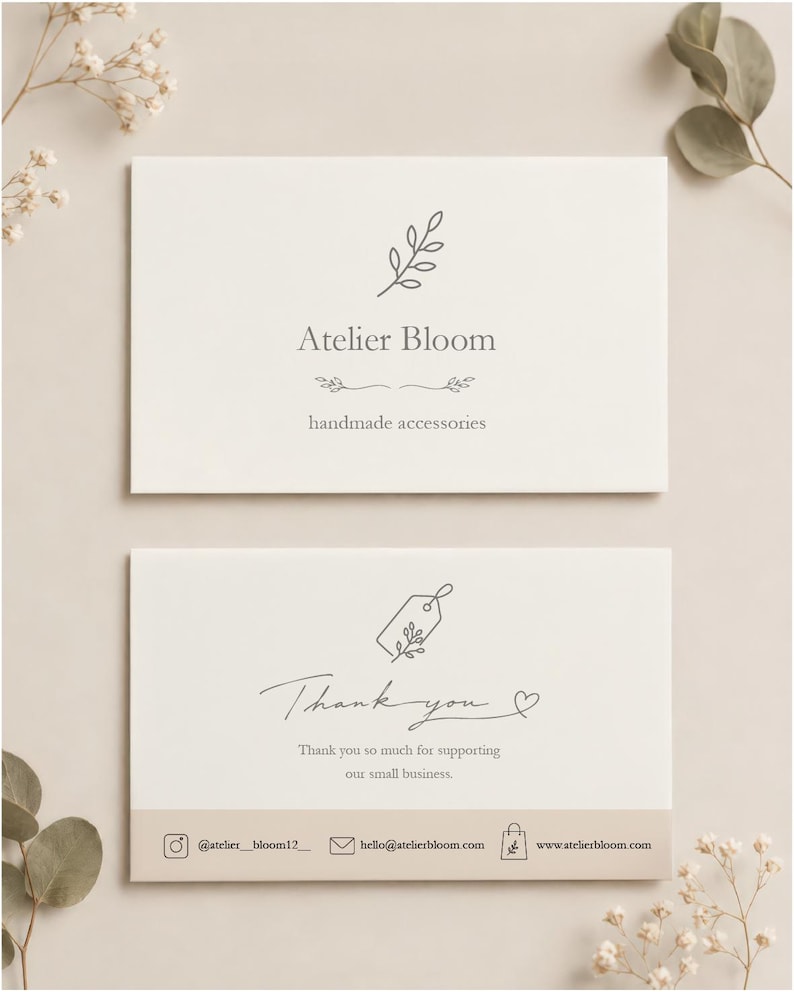 May include: Two rectangular white business cards with dark gray text and line art. The top card displays Atelier Bloom, handmade accessories, and a leaf icon. The bottom card features a thank you message, a tag icon, and contact information.
