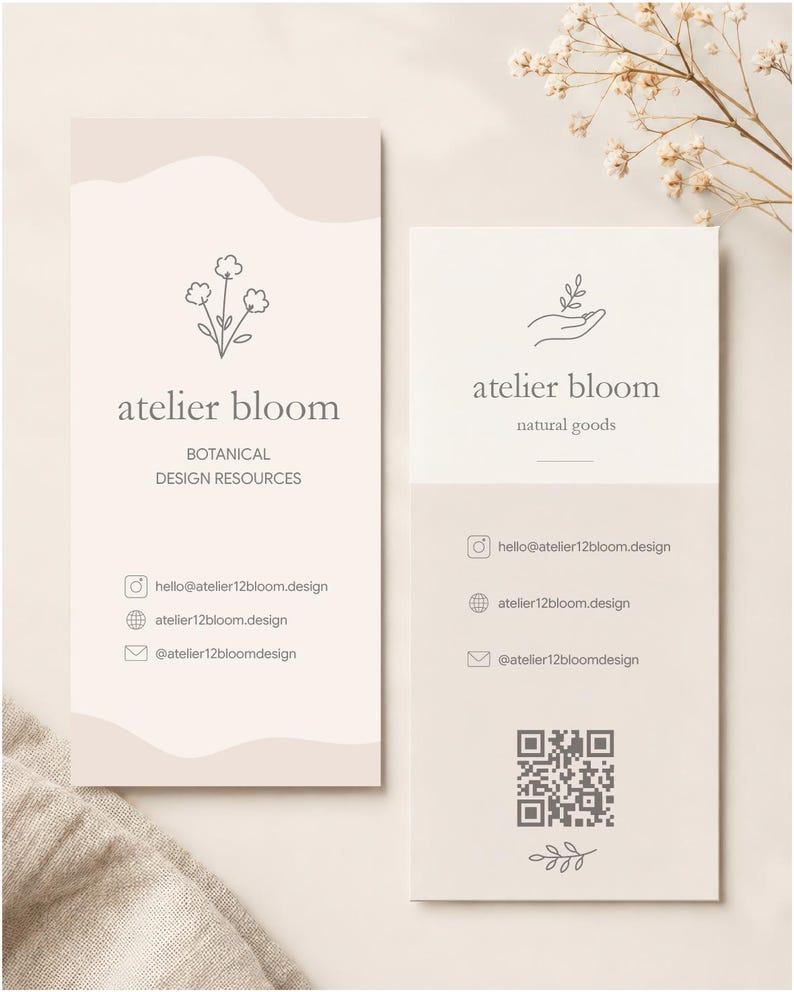 May include: Two rectangular business cards in beige and white. The left card features a flower icon, the text atelier bloom, BOTANICAL DESIGN RESOURCES, and contact details. The right card shows a hand icon, atelier bloom, natural goods, contact details, a QR code, and a leaf icon.