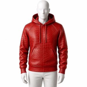 Op de afbeelding: Een felrode hoodie met een textuur van krokodillenleer over het hele kledingstuk. De hoodie is voorzien van een kangoeroezak aan de voorzijde, een capuchon met bijpassende rode trekkoorden en geribbelde boorden aan de mouwen en de onderkant.
