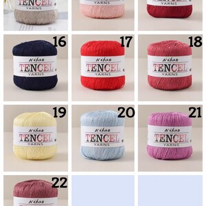 May include: A collection of ten cylindrical skeins of Nihao Tencel yarn in various colors, including beige, pink, red, navy, bright red, rose, yellow, light blue, purple, and mauve, each with a white paper label reading Nihao TENCEL YARNS.
