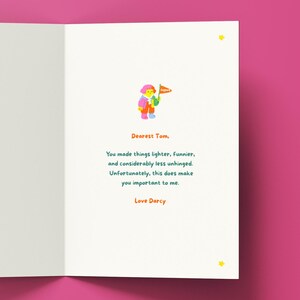 May include: A white greeting card with a small illustration of a figure holding an orange flag. The text reads: Dearest Tom, You made things lighter, funnier, and considerably less unhinged. Unfortunately, this does make you important to me. Love Darcy.