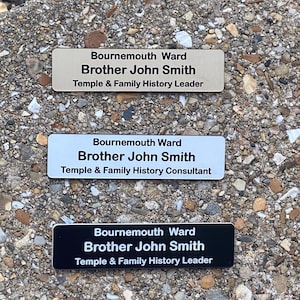 May include: Three rectangular name badges with rounded corners. The top badge is beige with black text, the middle is white with black text, and the bottom is black with white text. All feature the text Bournemouth Ward, Brother John Smith.