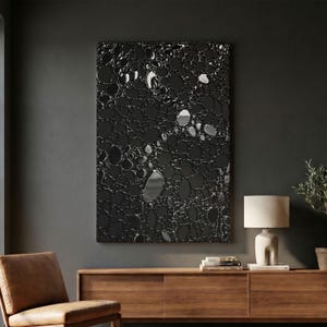 May include: A rectangular wall art piece featuring a high-contrast abstract pattern of interconnected black and metallic silver circular shapes. The design resembles a dense cluster of bubbles or organic cells with reflective surfaces against a dark background.