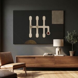 May include: A large rectangular wall art piece featuring a dark charcoal background with a central off-white gear shift pattern. The design includes a small red circle at the bottom right of the pattern and a textured light grey square in the top right corner.