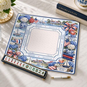 May include: A square mahjong mat featuring a coastal Charleston theme with blue and white hydrangeas, sailboats, American flags, and red-striped bows. It includes a central play area with game instructions, a tile rack with mahjong tiles, and a pen.