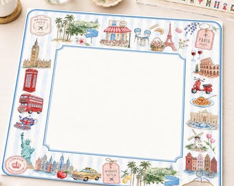 May include: A square paper placemat with a white center and a blue and white striped border featuring watercolor illustrations of global landmarks including the Eiffel Tower, Big Ben, the Statue of Liberty, Hollywood signs, and various travel icons.
