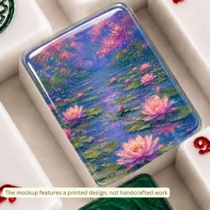 Peut inclure: Une tuile rectangulaire blanche orn&eacute;e d'une impression picturale vibrante de fleurs de lotus roses flottant sur un &eacute;tang bleu profond avec des n&eacute;nuphars verts. La surface est brillante et lisse, entour&eacute;e d'autres tuiles blanches marqu&eacute;es.