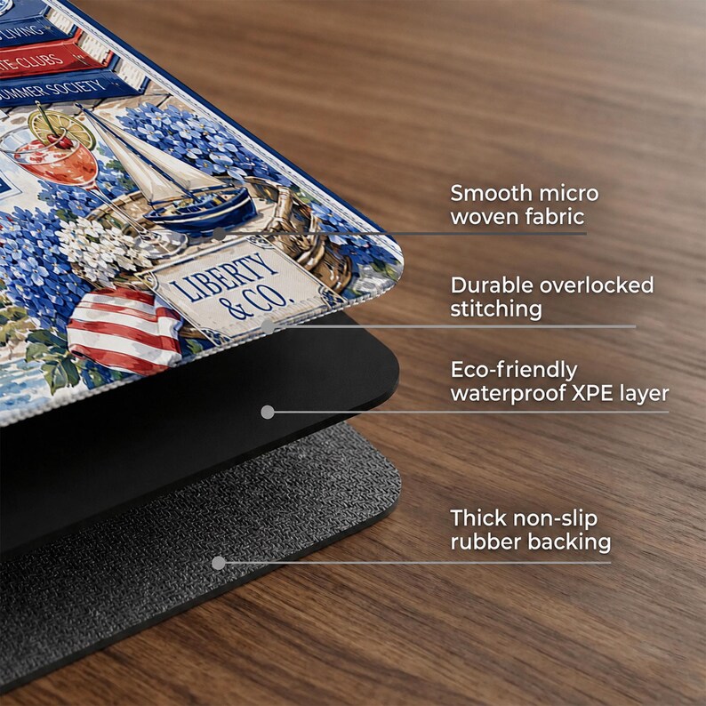 May include: A rectangular mouse pad featuring a nautical illustration with a sailboat, blue flowers, and a cocktail, labeled Liberty & Co. The pad consists of a smooth micro woven fabric top, durable overlocked stitching, a waterproof XPE layer, and a thick non-slip rubber backing.