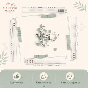 May include: A Mahjong set featuring four clear acrylic tile racks and a central pile of white tiles with green backs. The tiles display various red and black characters, dots, and bamboo symbols. The set includes a logo reading Mahjong Maison.