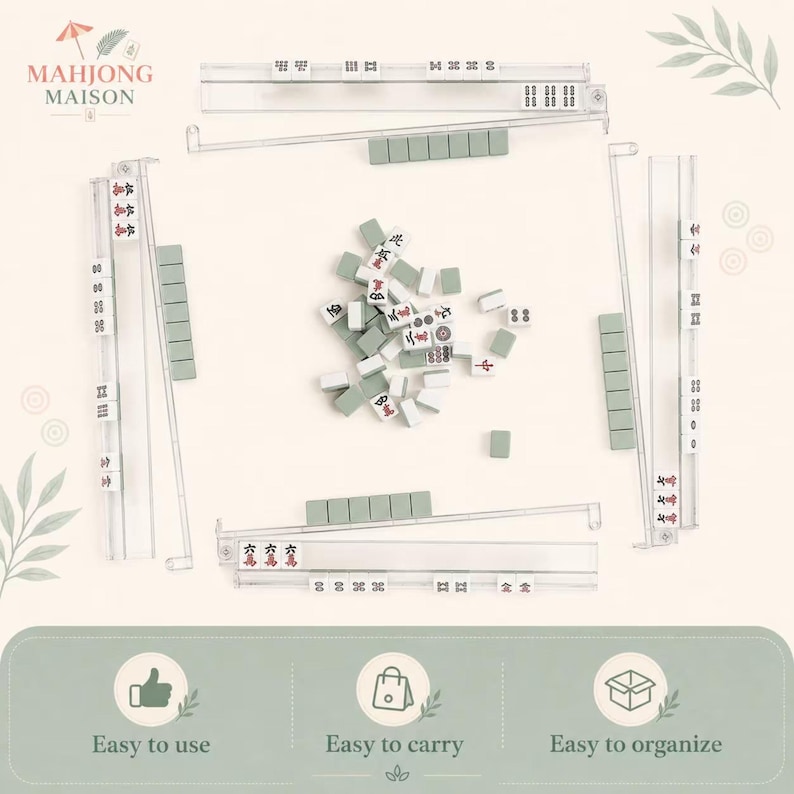 May include: A Mahjong set featuring four clear acrylic tile racks and a central pile of white tiles with green backs. The tiles display various red and black characters, dots, and bamboo symbols. The set includes a logo reading Mahjong Maison.