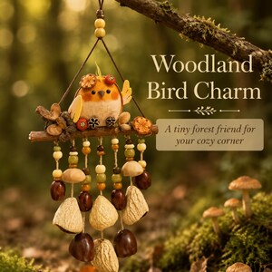 May include: A hanging ornament featuring a small orange bird perched on a branch, adorned with dried orange slices, acorns, and beads. Below the branch, multiple strings hang down, decorated with wooden beads, brown nuts, and textured shells.