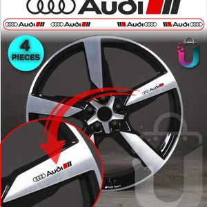 Può includere: Un set di quattro adesivi per cerchi in lega neri e argento con il logo e il testo Audi. Gli adesivi sono progettati per i cerchi dei veicoli e presentano un motivo a cinque razze con il marchio Audi Sport visibile sul bordo del cerchio.