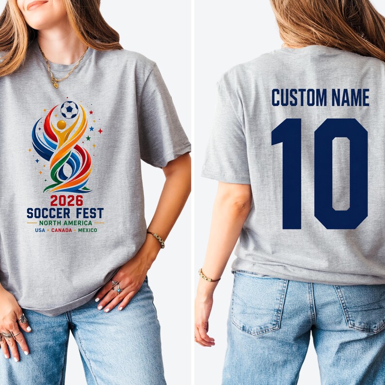 May include: A grey t-shirt featuring a colorful graphic on the front with a soccer ball, abstract shapes, and the text 2026 SOCCER FEST NORTH AMERICA USA CANADA MEXICO. The back displays the text CUSTOM NAME above the large dark blue number 10.