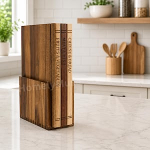 May include: A set of three rectangular wooden chopping boards stored upright in a matching wooden stand. The boards feature engraved labels on their edges reading FRUITS & VEGETABLES, MEAT & FISH, and CHEESE & BREAD in a dark brown font.