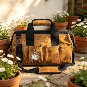 Pode incluir: Uma bolsa de ferramentas de lona encerada bege com acabamento preto, duas alças superiores e uma alça de ombro removível. A frente possui quatro bolsos externos e uma ilustração de ferramentas de jardinagem com o texto "Olivia's Garden".