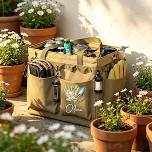 Op de afbeelding: Een beige canvas utility-draagtas met meerdere buitenzakken, voorzien van een opdruk van tuinhandschoenen en een troffel met de naam Olivia in witte schrijfletters. De tas bevat diverse voorwerpen en heeft twee draaghengsels.