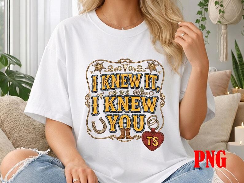 May include: A white short-sleeved t-shirt featuring a graphic design with the text I KNEW IT, I KNEW YOU in yellow with blue outlines. The design includes western-themed illustrations like sheriff stars, a horseshoe, boots, and a red heart tag.