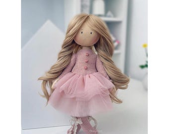 May include: A handmade doll with long blonde hair, wearing a pink dress with a tulle skirt and pink shoes. The doll has a pink knitted sweater with buttons.
