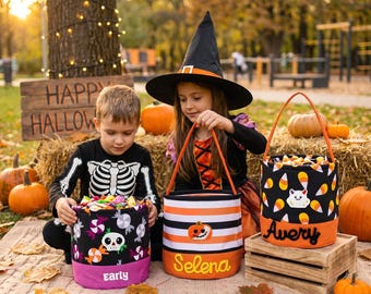 May include: Three cylindrical fabric Halloween candy buckets with handles. One is black with skulls and sweets, labelled Early. One is orange, white, and black striped with a pumpkin, labelled Selena. One is black with candy corn, labelled Avery.