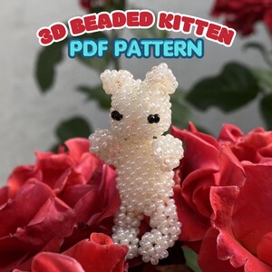 May include: A 3D beaded kitten figure constructed from small, translucent white beads with two black bead eyes. The text 3D BEADED KITTEN PDF PATTERN is displayed in red and blue letters above the small, upright, standing animal figurine.