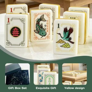 May include: A set of rectangular Mahjong tiles featuring white surfaces with gold edges and various colorful illustrations including a red pagoda, a green koi fish labeled Joker, and a crane. The set includes a black gift box with black filler.